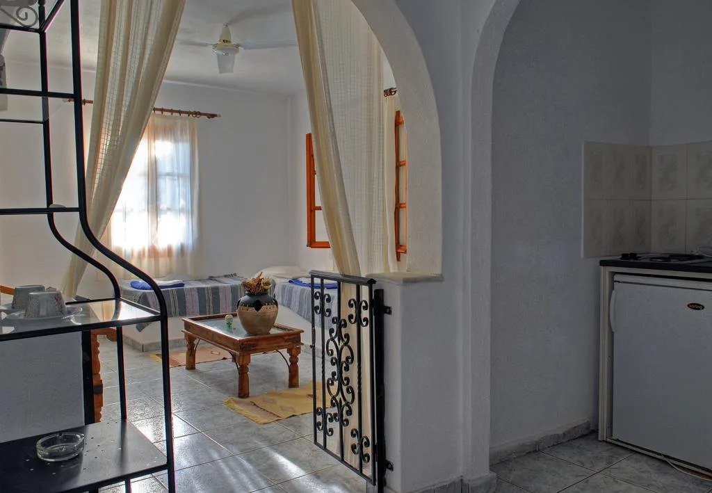 Room with two single beds and kitchen